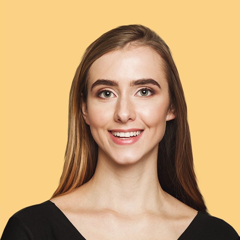 Smiling woman with long hair and natural makeup against a bright yellow background, representing the friendly and professional image of Exit Cleans cleaning service.